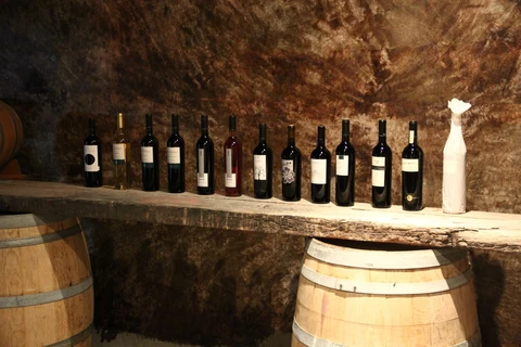 red wine lined up on a barrel