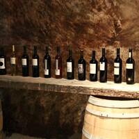 red wine lined up on a barrel